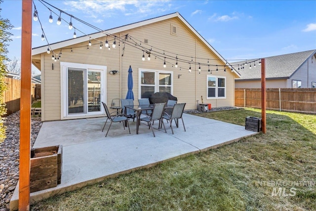 rear view of house with a yard, a fenced backyard, and a patio