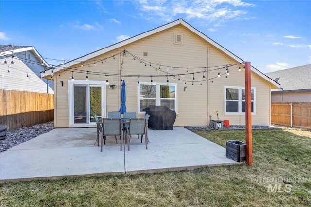 back of house with a patio area, a lawn, and a fenced backyard