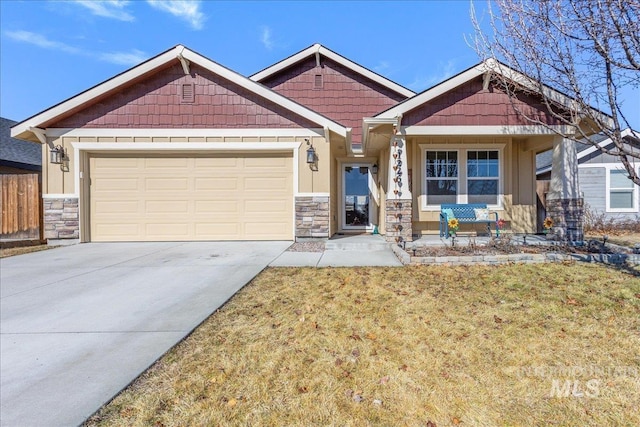 craftsman-style house with a garage, concrete driveway, stone siding, and fence