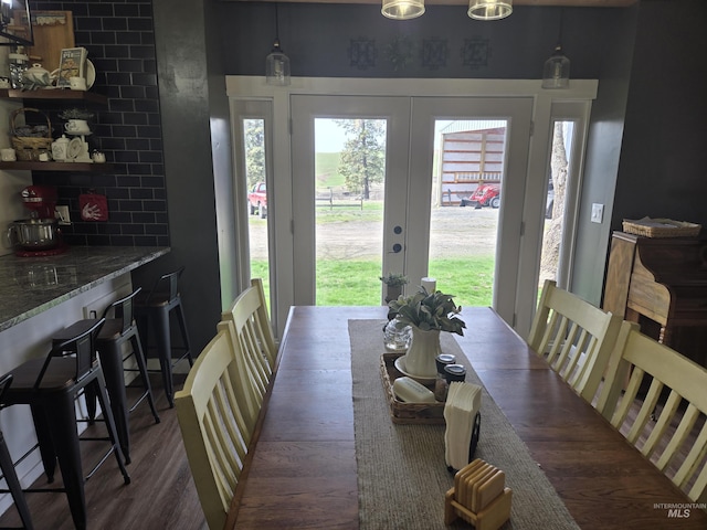 dining space with french doors and wood finished floors