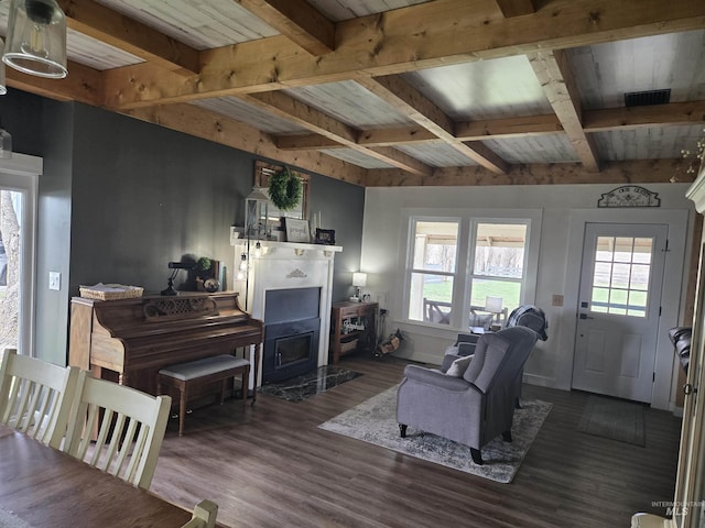 living area featuring baseboards, coffered ceiling, wood finished floors, and beamed ceiling