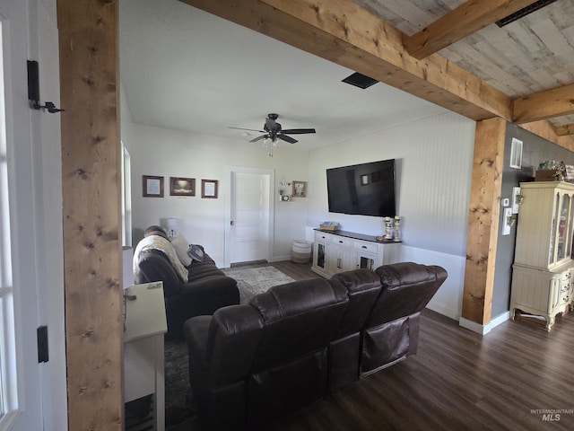 living room with a ceiling fan, baseboards, beam ceiling, and wood finished floors