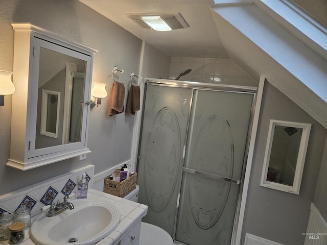 full bathroom with vanity, visible vents, a shower stall, and toilet