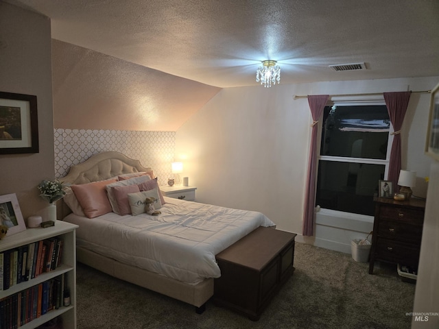 bedroom with a textured ceiling, carpet floors, and visible vents