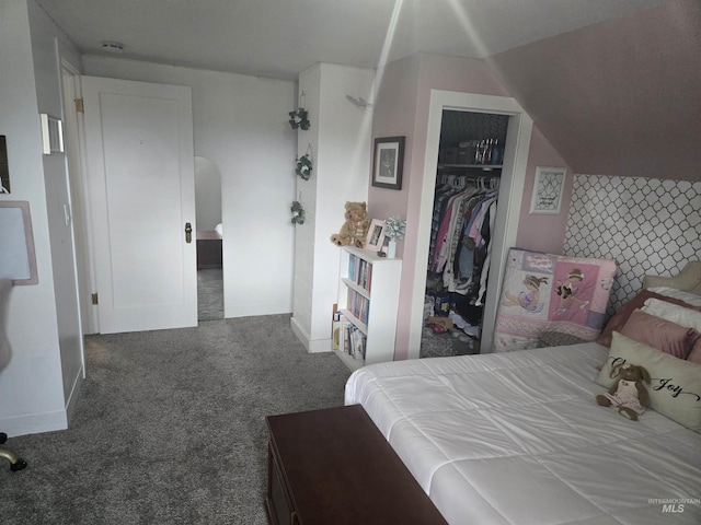 carpeted bedroom featuring arched walkways, a closet, and baseboards