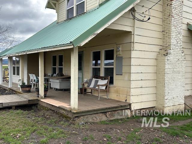 rear view of house featuring a deck and metal roof