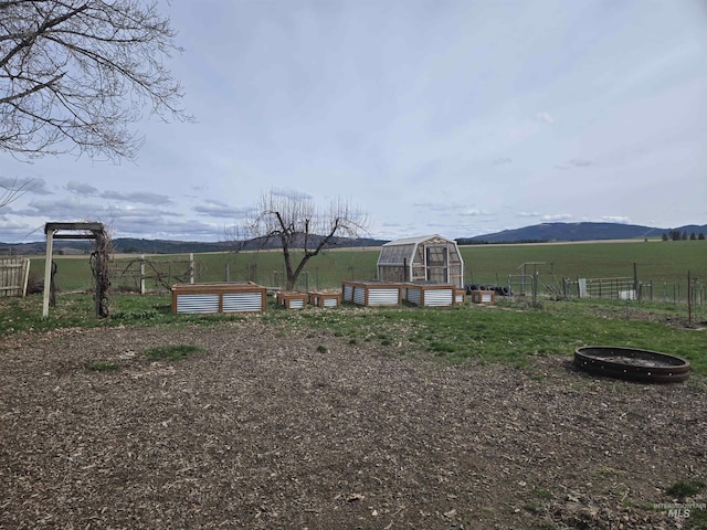view of yard with an exterior structure, a vegetable garden, fence, and an outdoor structure
