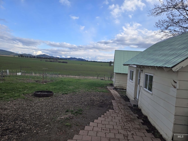 view of yard with a rural view and a mountain view
