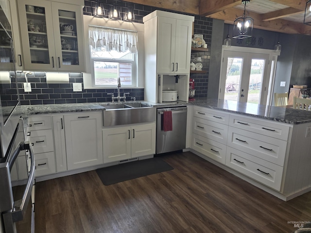 kitchen featuring white cabinets, a peninsula, stainless steel dishwasher, a sink, and dark wood-style flooring