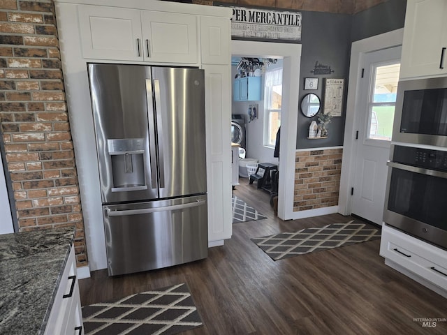 kitchen with white cabinets, dark stone counters, dark wood-type flooring, and appliances with stainless steel finishes