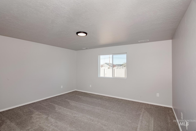 unfurnished room featuring a textured ceiling and carpet flooring