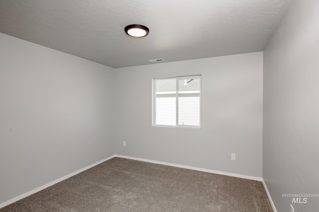 unfurnished room with a textured ceiling and carpet floors