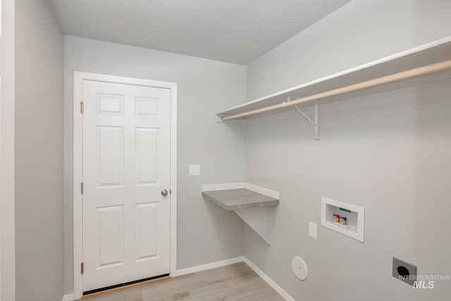 clothes washing area with light hardwood / wood-style floors, washer hookup, and hookup for an electric dryer