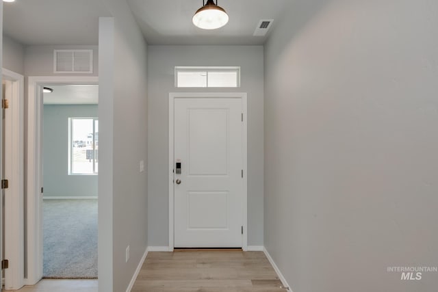 doorway to outside with a healthy amount of sunlight and light colored carpet