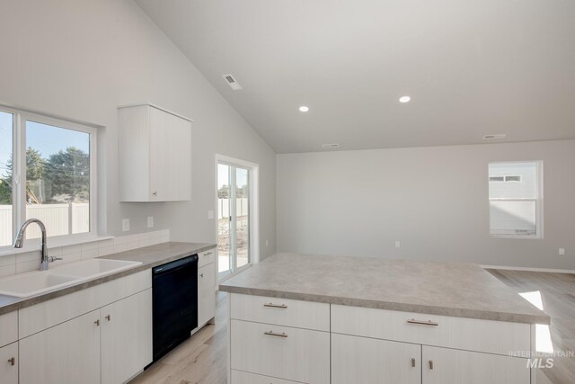 kitchen featuring plenty of natural light, sink, light hardwood / wood-style floors, and black dishwasher