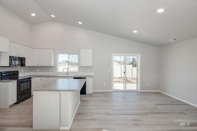 kitchen featuring light hardwood / wood-style flooring, white cabinetry, black appliances, a center island, and high vaulted ceiling