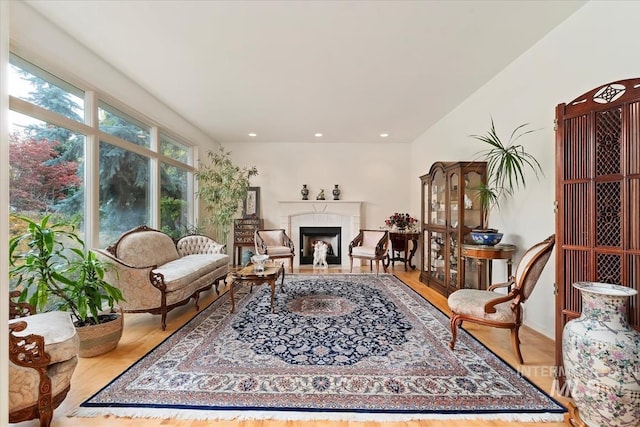 sitting room with light hardwood / wood-style floors and a tiled fireplace