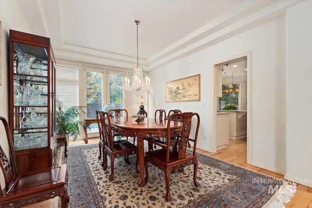 dining area featuring a tray ceiling and an inviting chandelier