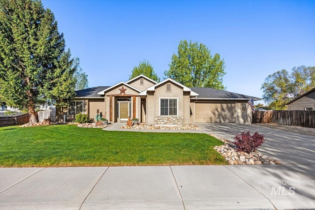 ranch-style home featuring an attached garage, a front lawn, fence, and driveway