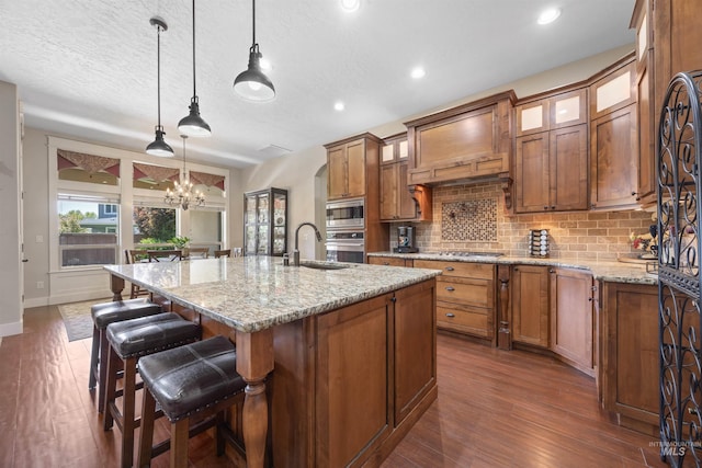 1573 E Commander St, Meridian, ID 83646 - kitchen with appliances with stainless steel finishes, backsplash, brown cabinetry, glass insert cabinets, and dark wood-type flooring