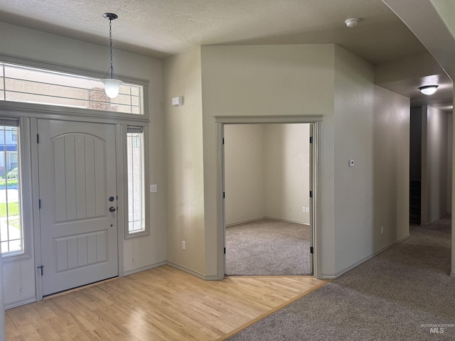 3669 N Dixon Ave, Meridian, ID 83646 - entrance foyer with arched walkways, light wood-style flooring, healthy amount of natural light, and a textured ceiling