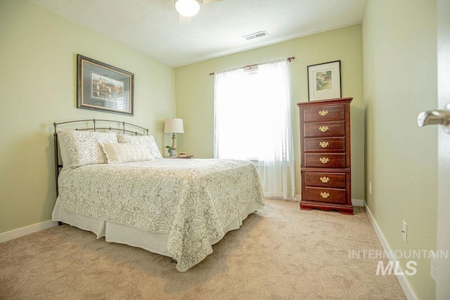 bedroom with baseboards, visible vents, and light colored carpet