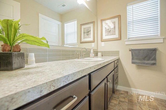 bathroom featuring baseboards, visible vents, and vanity