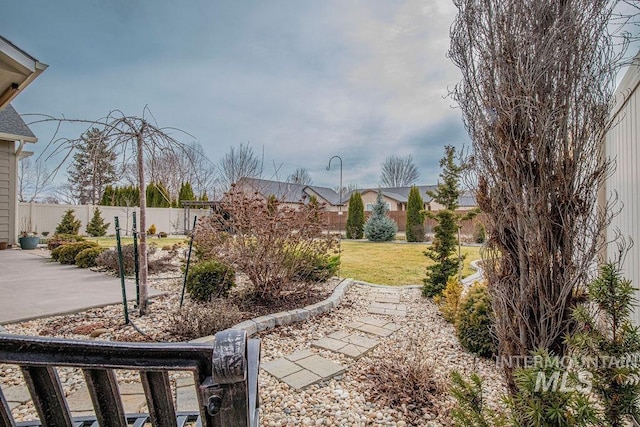 view of yard with fence and a patio