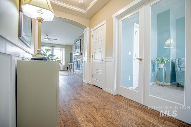 corridor featuring arched walkways and hardwood / wood-style floors