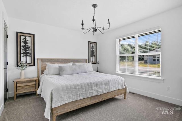 carpeted bedroom featuring an inviting chandelier