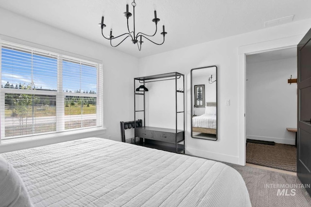 carpeted bedroom with a notable chandelier