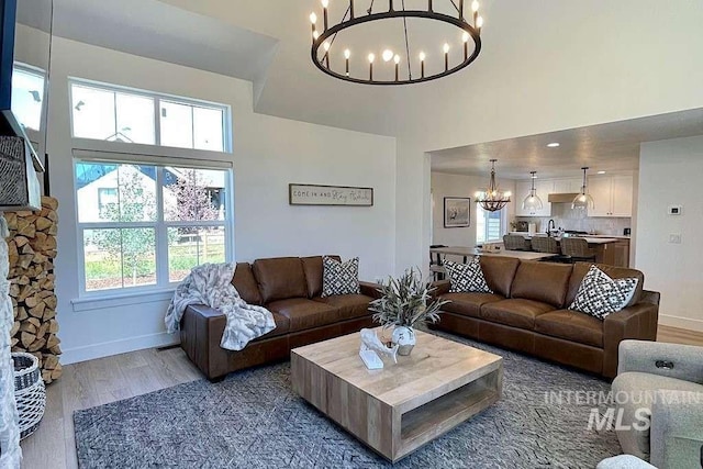 living room with hardwood / wood-style floors, a high ceiling, and a chandelier