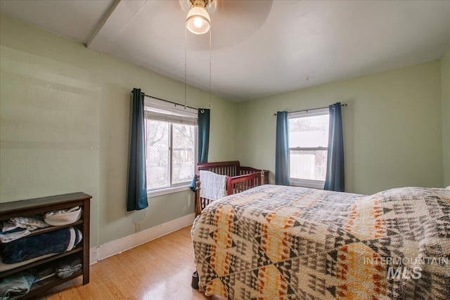 bedroom with wood finished floors, baseboards, and ceiling fan