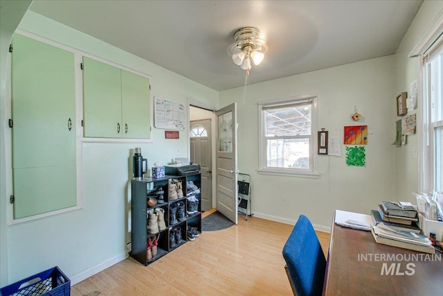 office space with light wood finished floors, baseboards, and a ceiling fan