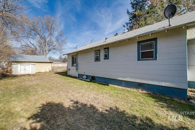 back of property featuring an outbuilding, a storage shed, and a yard