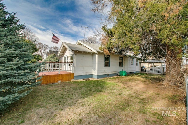 back of house featuring a shingled roof, a wooden deck, a yard, and crawl space