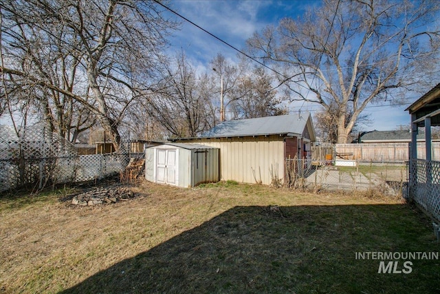 view of yard featuring a storage shed, a fenced backyard, and an outdoor structure