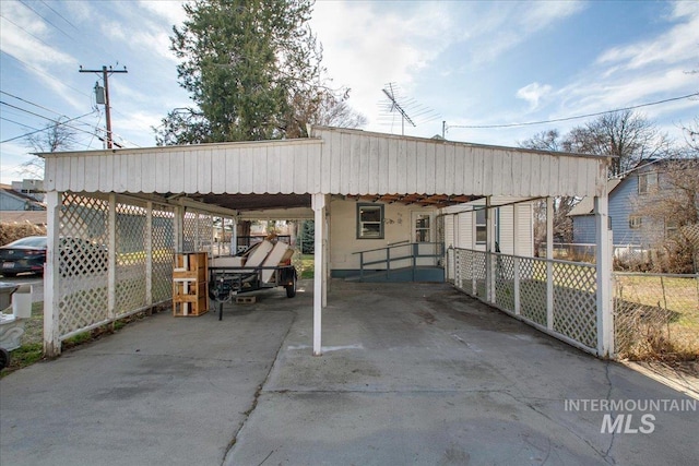 view of car parking featuring driveway and fence