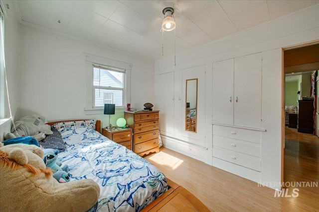 bedroom featuring crown molding and wood finished floors