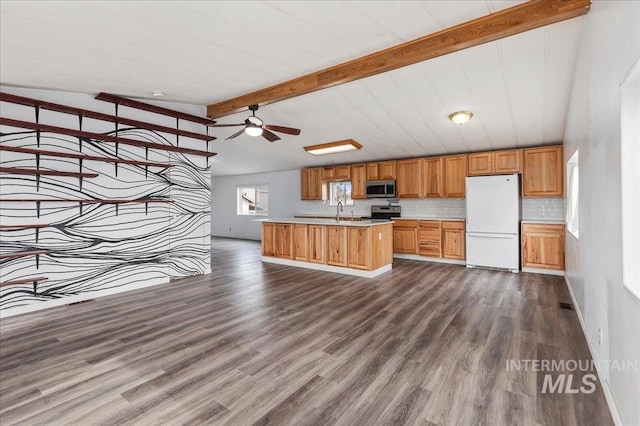 kitchen with brown cabinetry, dark wood finished floors, light countertops, appliances with stainless steel finishes, and backsplash