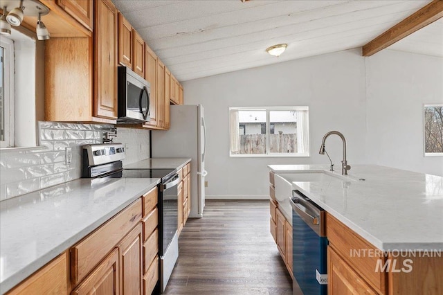 kitchen with a sink, stainless steel appliances, decorative backsplash, and vaulted ceiling with beams