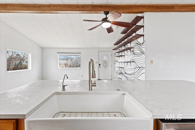 interior details featuring light countertops, a ceiling fan, and a sink