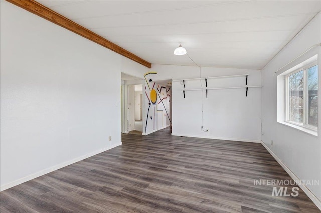 spare room with dark wood finished floors, vaulted ceiling with beams, and baseboards