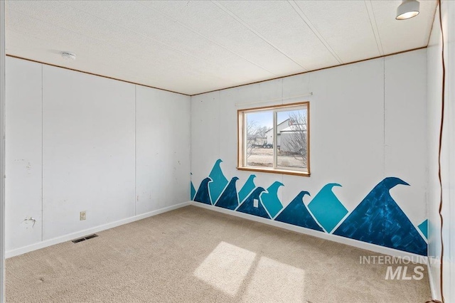 unfurnished room featuring carpet flooring, baseboards, visible vents, and a textured ceiling