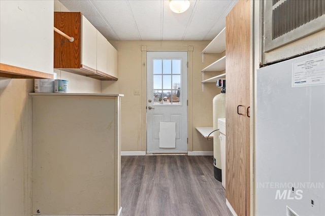 washroom featuring dark wood finished floors, laundry area, and baseboards