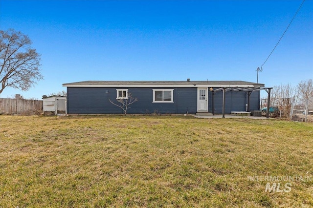 rear view of house with central air condition unit, a lawn, entry steps, and fence