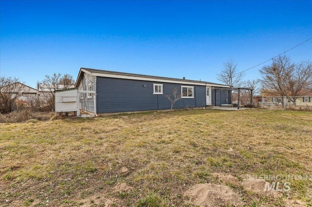 back of property featuring a yard and fence