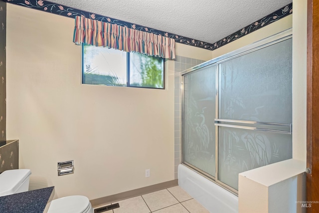 1332 Burrell Ave, Lewiston, ID 83501 - full bath with toilet, tile patterned flooring, a textured ceiling, shower / bath combination with glass door, and baseboards