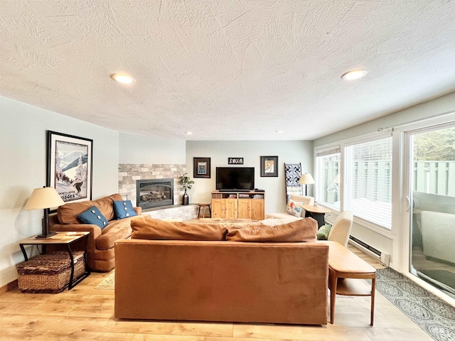 301 N Mission St Unit C3, Mccall, ID 83638 - living area with a baseboard radiator, a textured ceiling, a stone fireplace, light wood-style floors, and recessed lighting
