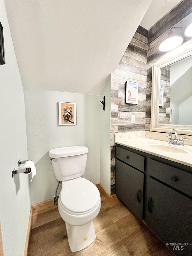 301 N Mission St Unit C3, Mccall, ID 83638 - half bathroom featuring wood walls, vanity, wood finished floors, and lofted ceiling